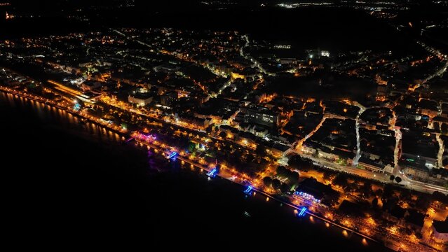 Aerial view of illuminated cityscape by the sea at night