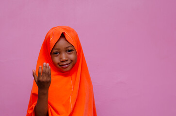 portrait of an african muslim young girl smiling and overexcited, gesturing with her hand