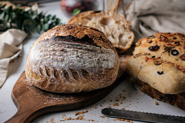 Artisan Batard Sourdough healthy Bread with leaf scoring. Open crumb high hydration Sourdough bread set on white table. - 606024027