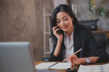 Asian business woman, sale manager, female entrepreneur is using a mobile phone to contact, making...