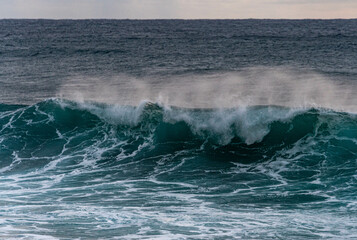 Fototapeta na wymiar Sich überschlagene Wellen mit Gischt und Schaum im Meer