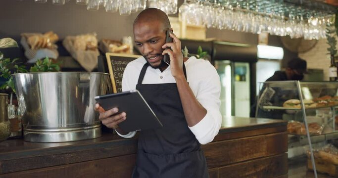 Cafe, order and a black man on a phone call with a tablet for restaurant stock, service and networking. Talking, waiter and an African barista or manager speaking on a mobile with tech for an email