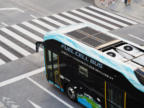 TOKYO, JAPAN - May 24, 2023: Overhead view of a hydrogen fuel cell bus at a crosswalk in Tokyo's Ginza area.