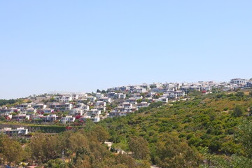 Fototapeta na wymiar View of the highway, houses and mountains on the Aegean coast of Turkey, orange groves. Turkiye, May 2023.