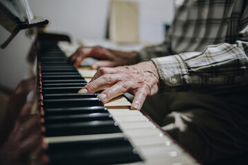Manos anciano tocando piano