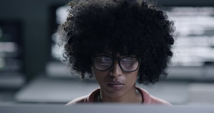 Technology, black woman programmer look at computer and working late at night at her workplace. Database or it service, software and African young female person develop website at workstation