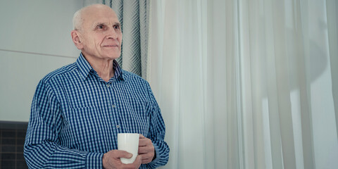 Portrait of old alone man with white coffee cup inside of room. Old people social isolation problem concept. - obrazy, fototapety, plakaty