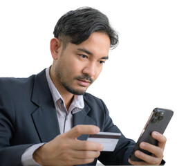 Handsome Asian business man in a suit is sitting and typing credit card number to mobile phone with a serious expression on his face.	