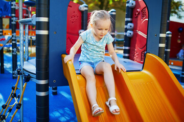 Adorable little girl on playground on a sunny day