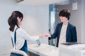 Obraz premium カフェでクレジットカード決済をする男性