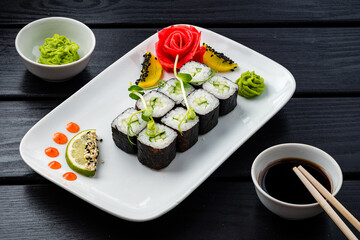 Vegetarian sushi rolls from cucumber, rice and nori with wasabi, ginger and soy sauce.