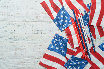 4th of July background. US flag paper napkin and picnic cocktail straws on old white table...