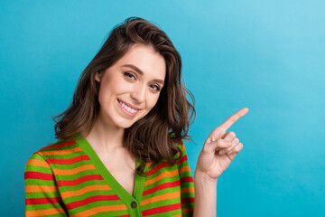 Closeup portrait of young girl wavy hair striped shirt indicate finger empty space new spa salon promo isolated on blue color background