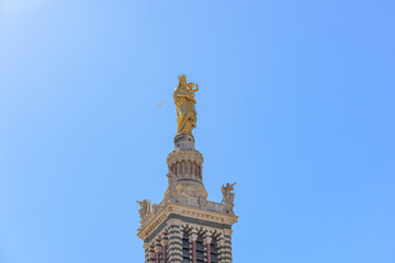 Fototapeta na wymiar A scenics view of the Basilique Notre-Dame-de-la-Garde, la Bonne Mère gold statue, Marseille, bouches-du-rhône, France under a majestic blue sky
