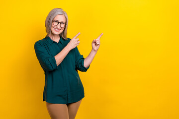 Photo of aged positive manager lady pointing finger empty space indicate promo isolated bright color background