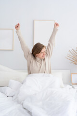 Fototapeta na wymiar Woman waking up at bed at home