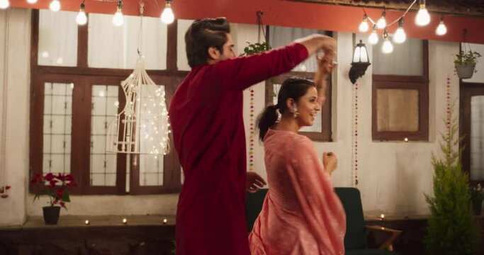 Cute Indian Young Couple Dancing and Having Fun in an Outdoor Party: Enjoying Each Other's Company and Playfully Moving to Music. With Joyful Laughter and Smiles, Celebrating their Youth and Love