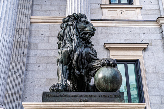 Horizontal image of one of the bronze lions that protect the entrance of the congress of spain, in madrid, cast with cannons of the war of africa.