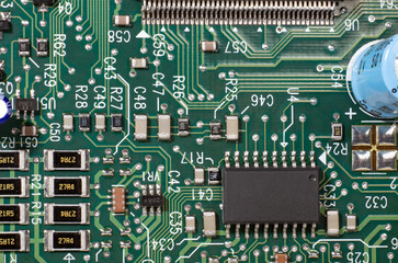 Macro Closeup Green Computer Electronic Circuit board with chips solder traces pads and lettering