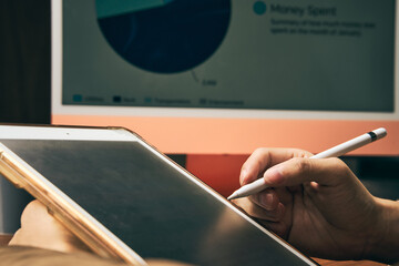 businessman working on finance report in the office by using computer and tablet technology with graph and statistic information
