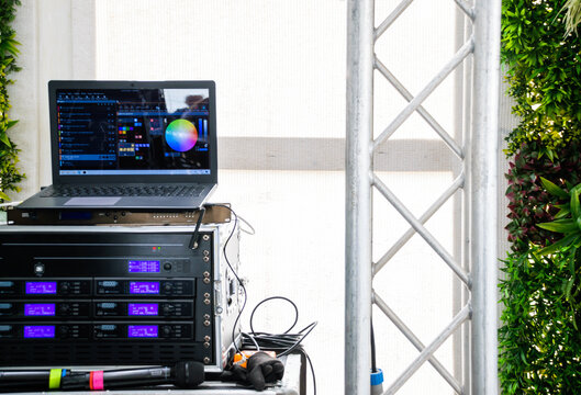 Image of sound and light system with laptop, microphones and DJ mixers