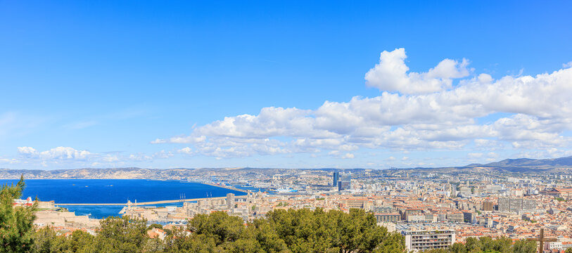A scenics aerial view of the city of Marseille, bouches-du-rh&ocirc;ne, France under a majestic blue sky and some white clouds