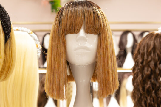 Multi-colored wigs are worn on the heads of mannequins.