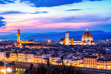 Fototapeta na wymiar The view of the towers of the Palazzo Vecchio and the Cattedrale di Santa Maria del Fiore from Piazza Michelangelo in Florence at sunset.