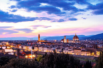 Fototapeta na wymiar The view of the Ponte Vecchio, the towers of the Palazzo Vecchio and the Cattedrale di Santa Maria del Fiore from Piazza Michelangelo in Florence at sunset.