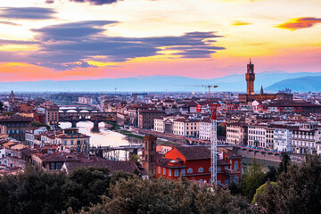 Fototapeta na wymiar The view of the Ponte Vecchio and the towers of the Palazzo Vecchiorom Piazza Michelangelo in Florence at sunset.