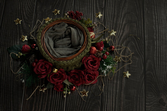 Newborn digital backdrop with crochet basket, red handmade roses and christmas decoration on wooden background. Newborn christmas background. smooth oil paint efect in flowers.