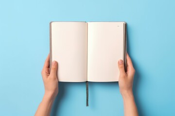 Hands holding open notebook with blank pages, blue background, Generative AI
