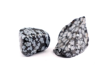 Two snowflake obsidian semi precious stones, one polished and one raw,  on white background.	