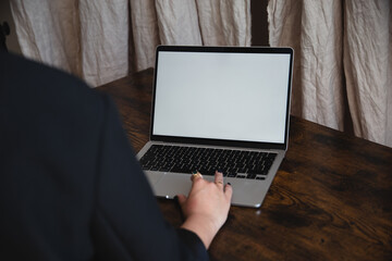 Women working, laptop in a lap, wooden table, browsing computer with blank screen mock-up for your design at home office with blurry background with free space for custom text about business