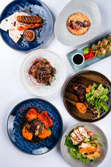 Set of marbled beef kebab, tenderloin steak, veal cheeks, tomato risotto with anchovies, lettuce and beef rib on white background.
