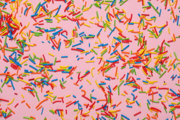 Many Colored sugar Easter sprinkles or Cake decoration on a pink background.