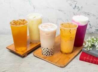 Assorted Fruit iced tea include Passion fruit, Pearl milk, Dragon Cheese Milk, Guava Lemonade iced, Osmanthus Oolong, served in disposable glass isolated on background top view of taiwan drink