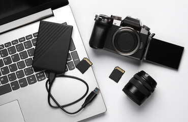 Laptop, external hard drive, modern digital camera with flip screen, two sd memory cards and lens...