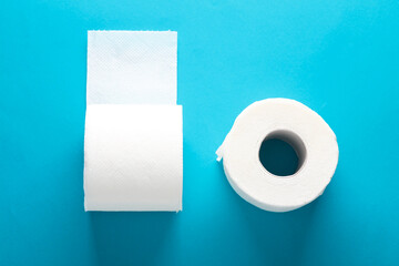 Two rolls of white toilet paper on a blue background with a shadow