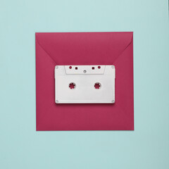 Square envelope with a white audio cassette on a blue background. Creative layout
