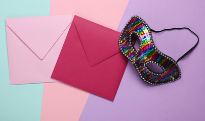 Invitation envelopes with carnival mask on pastel background