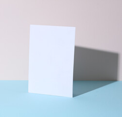 White blank greeting card on pastel background with shadow. Creative layout