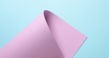 Pastel color trend. Wrapped lavender sheet of paper on blue background