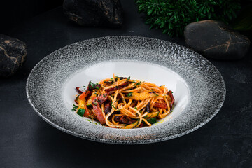 Lunch pasta with bacon, zucchini, greens and sauce in plate.