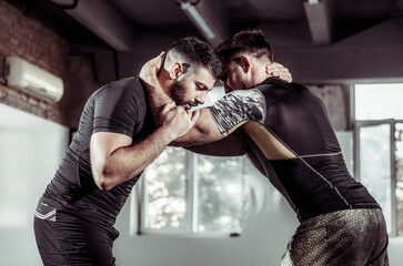 Sparring training of two athletic mma fighters in the gym. Martial arts, Wrestling