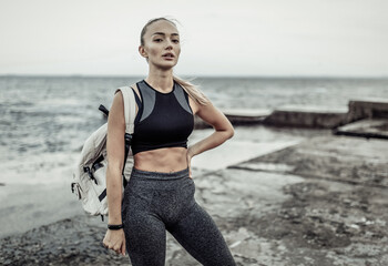 Fototapeta na wymiar Portrait of young fit woman in sportswear on urban beach