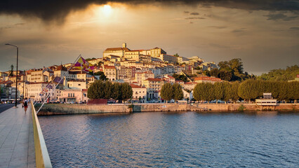 Fototapeta na wymiar Coimbra city seen from across the Mondego River at sunset, Portugal