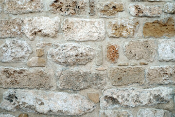 Vintage wall of old natural limestone as background front view close up