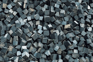 Basalt cubes as background. Pile of natural stone cubes for making outdoor pavement tiles.