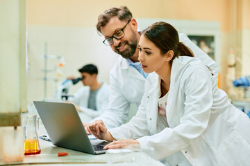 Two scientists working on computer in laboratory.